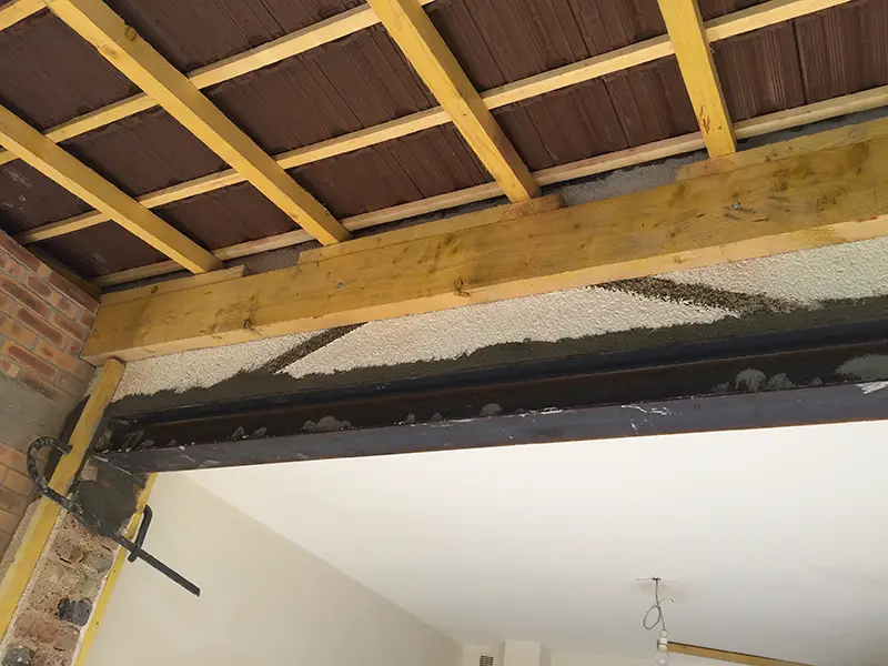 Installation d'une poutre IPN métallique pour remplacer un mur porteur abattu dans un salon