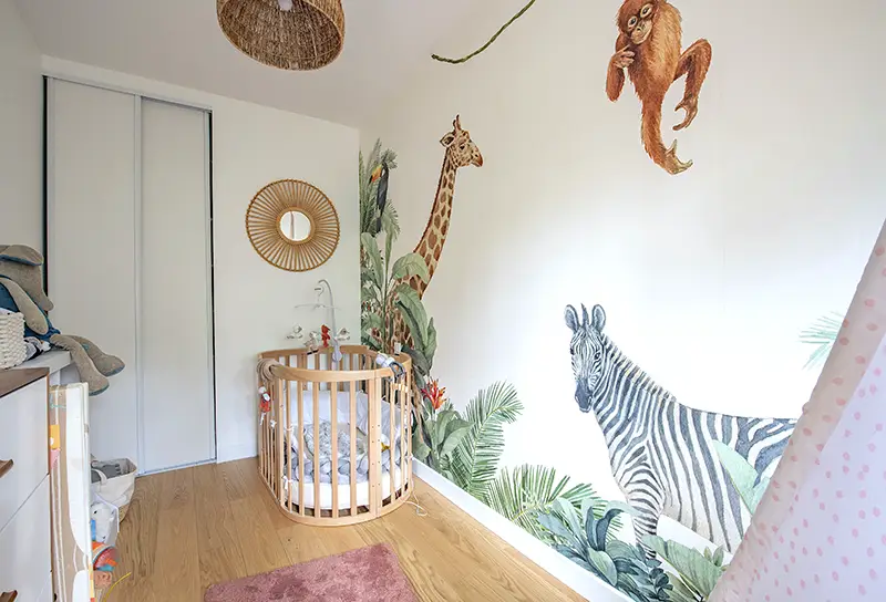 Chambre d'enfant colorée avec papier peint à motifs géométriques associé à de la peinture unie sur les murs adjacents