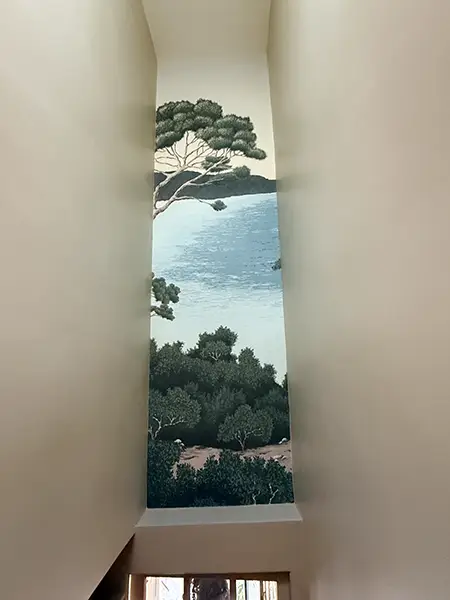 Couloir élégant avec papier peint panoramique sur un mur et peinture claire sur les autres pour agrandir l'espace