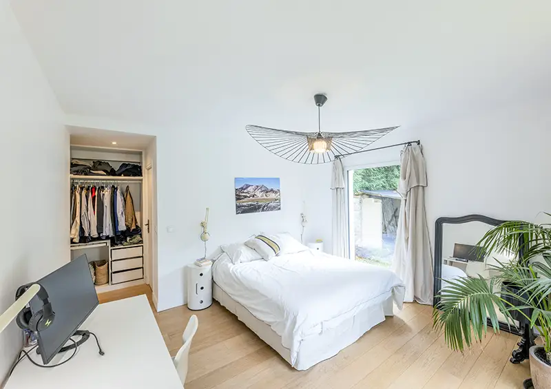 Bureau télétravail installé dans une chambre rénovée avec étagères murales, éclairage LED et chaise ergonomique