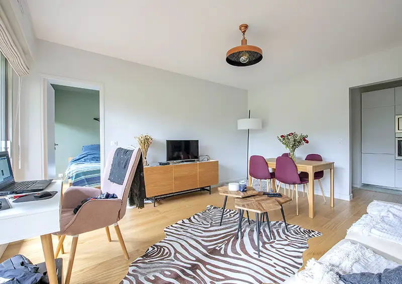 Espace de télétravail discret intégré dans un salon après rénovation avec bibliothèque sur mesure et câbles dissimulés