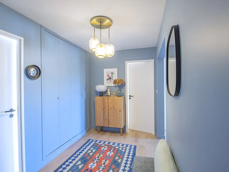 Couloir moderne avec luminaire suspendu, lumière blanche pour éviter les zones d'ombre en rénovation