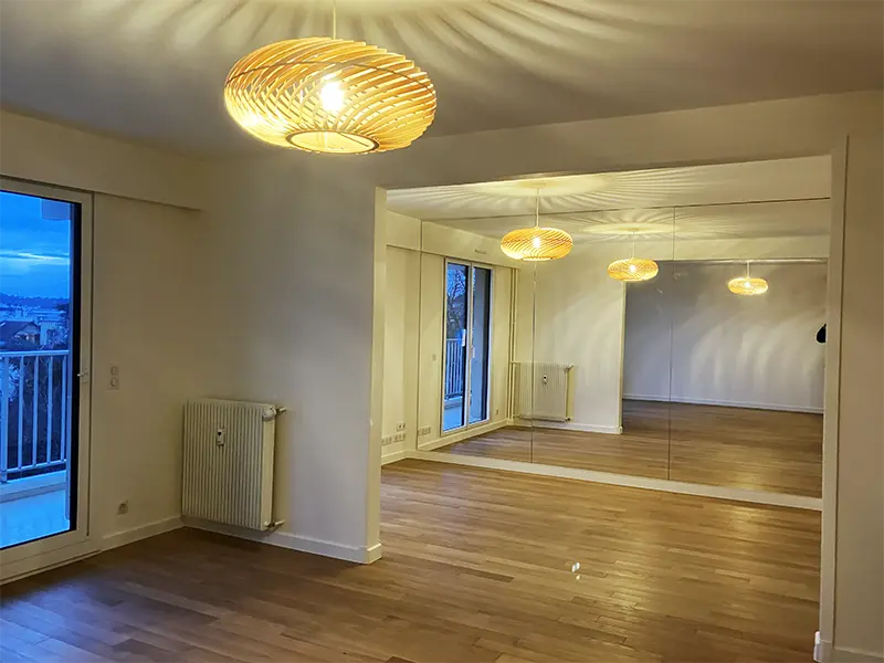 Luminaire suspendu dans un salon rénové, éclairage général chaleureux combiné à un éclairage d'ambiance