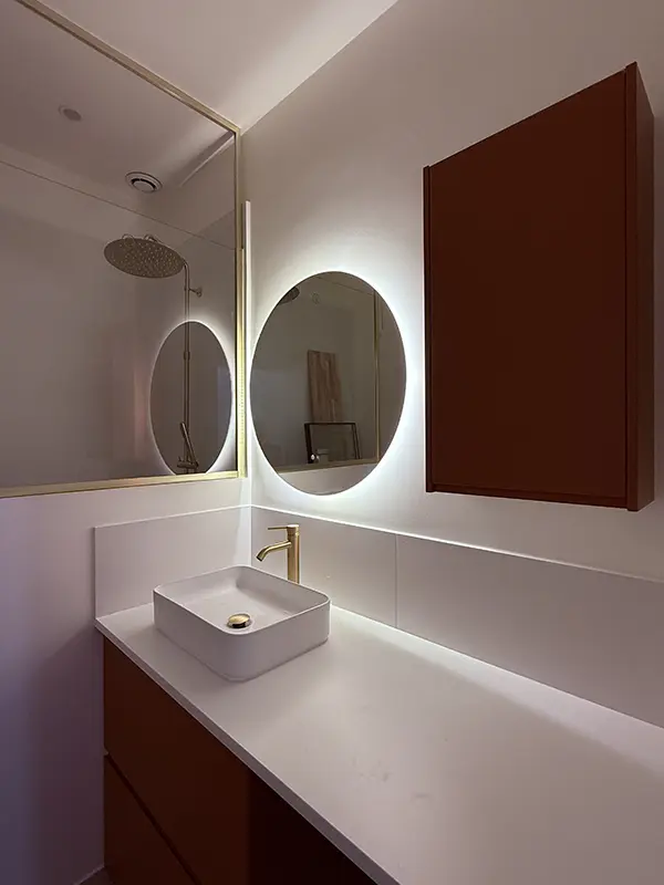 Double applique design dans une salle de bain moderne, éclairage fonctionnel et décoratif en rénovation