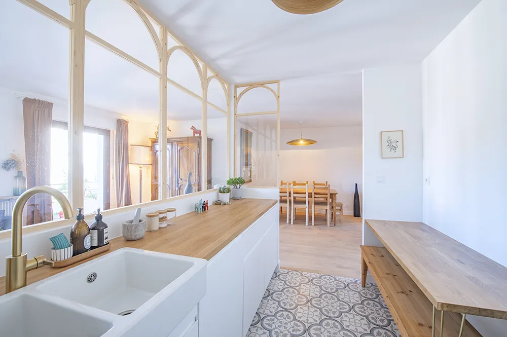 Verrière en bois séparant la cuisine du salon dans un appartement rénové