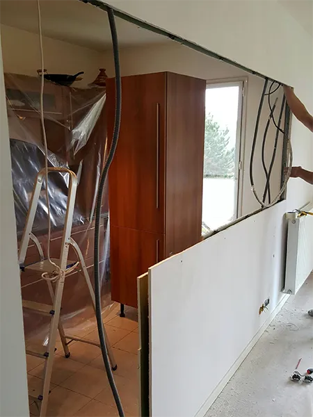 Installation d'une verrière intérieure en cours de travaux dans une cuisine en rénovation