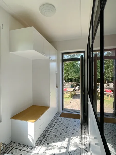 Verrière intérieure délimitant l'entrée de la pièce de vie dans un appartement rénové